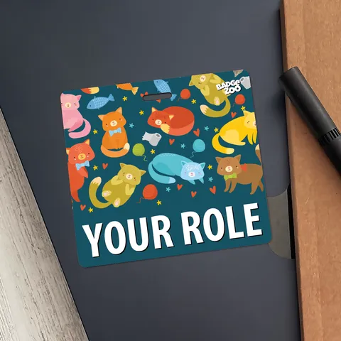 Teal kitten pattern badge buddy with YOUR ROLE text pinned on a black folder with a brown card edge