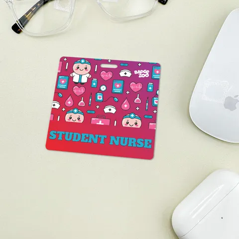 Student nurse badge buddy on a desk beside glasses and a computer mouse