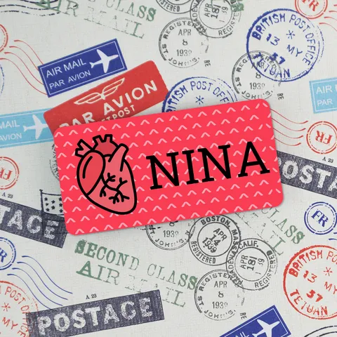 Red heart name badge reading NINA on vintage airmail stamp background with postage and air mail marks