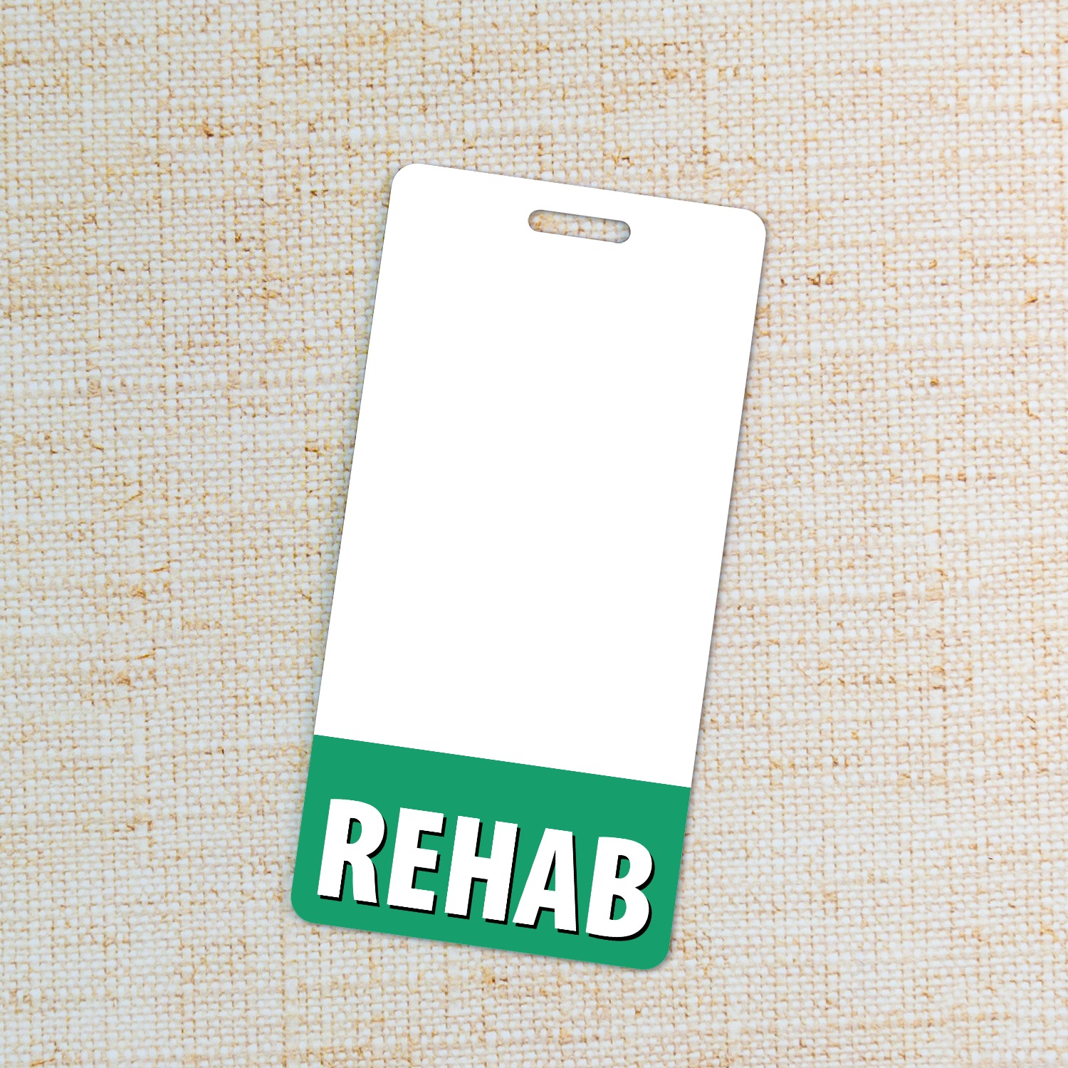 Vertical REHAB badge buddy with green band on cream linen fabric background