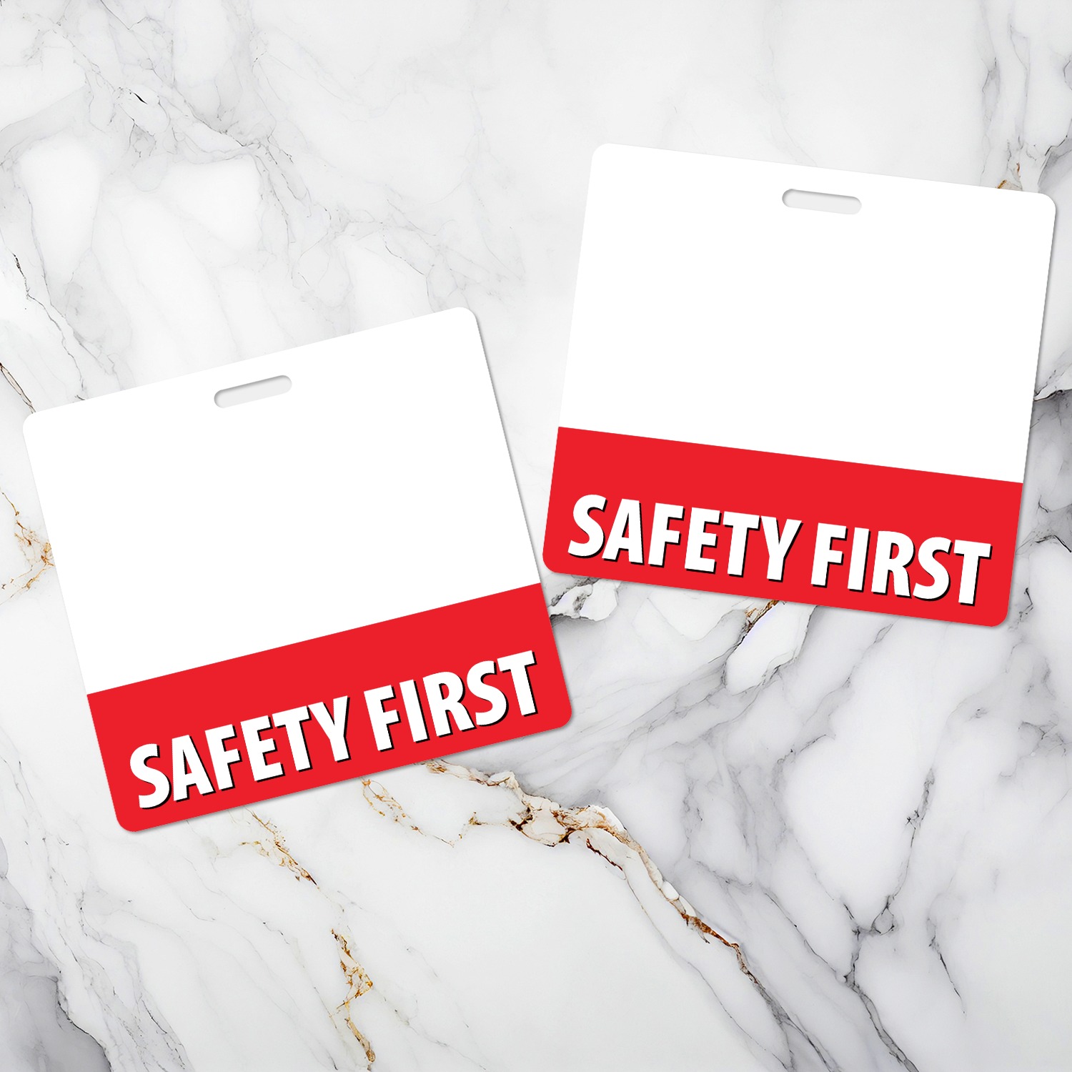 Two horizontal SAFETY FIRST badge buddies on white marble, white top with red band and bold white text