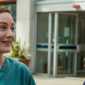Nurse and paramedic smiling outside hospital entrance during a shift