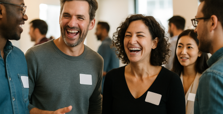 Group of smiling professionals wearing blank name tags while networking at a lively indoor event.
