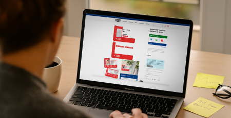 Person browsing the BadgeZoo website customizing a red Medical ID Card on a laptop screen