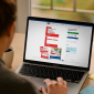 Person browsing the BadgeZoo website customizing a red Medical ID Card on a laptop screen